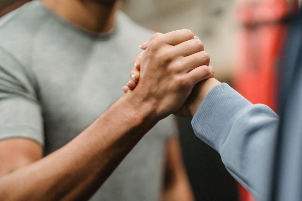 pexels-photo-6456305 Crop sportive couple clasping hands in gym